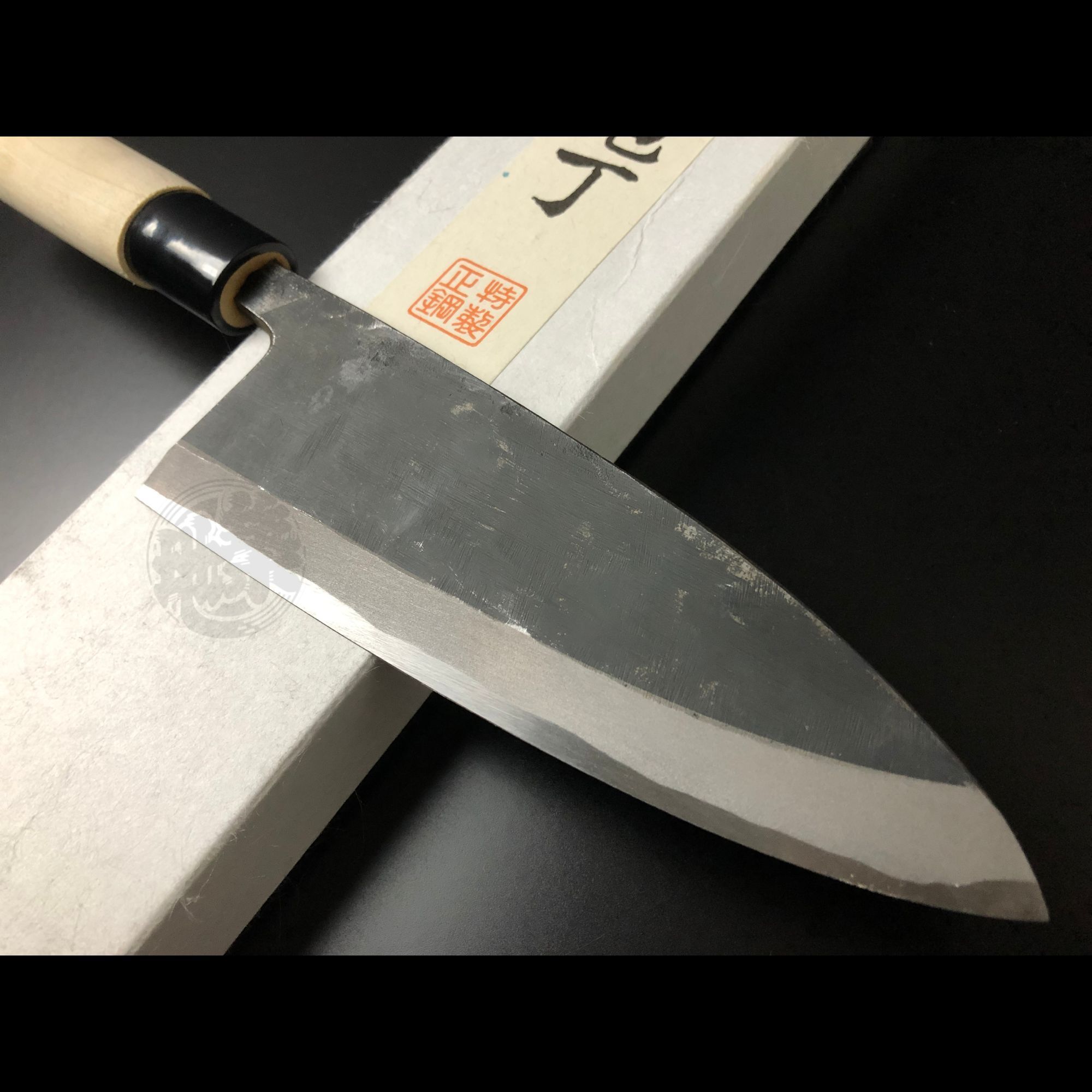 Authentic Tsukiji Aritsugu black Deba knife with a rustic black-forged finish for heavy-duty butchery.